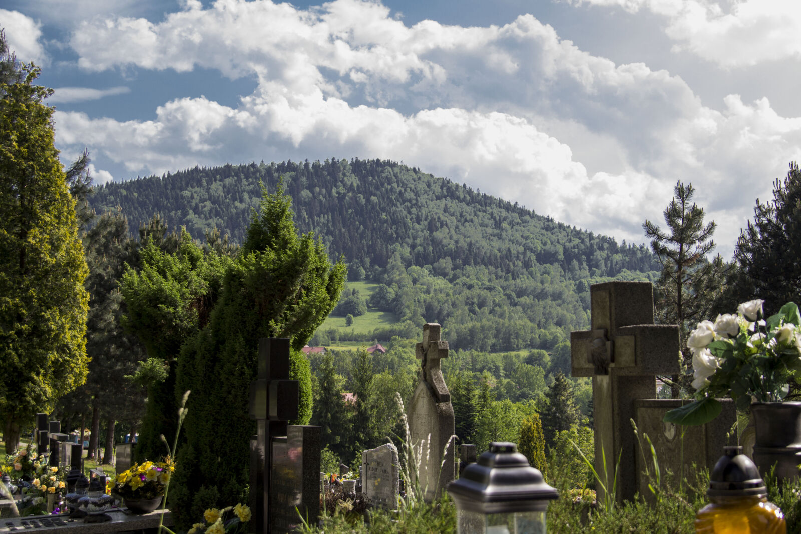 Canon EF 28-135mm F3.5-5.6 IS USM sample photo. Cemetery, clouds, cross, mountains photography