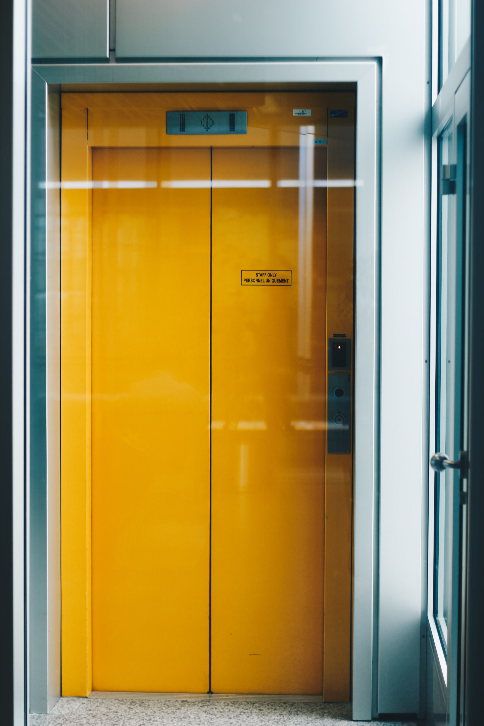 Canon EOS 700D (EOS Rebel T5i / EOS Kiss X7i) + Canon EF 50mm F1.8 II sample photo. Closed, yellow, elevator, door photography