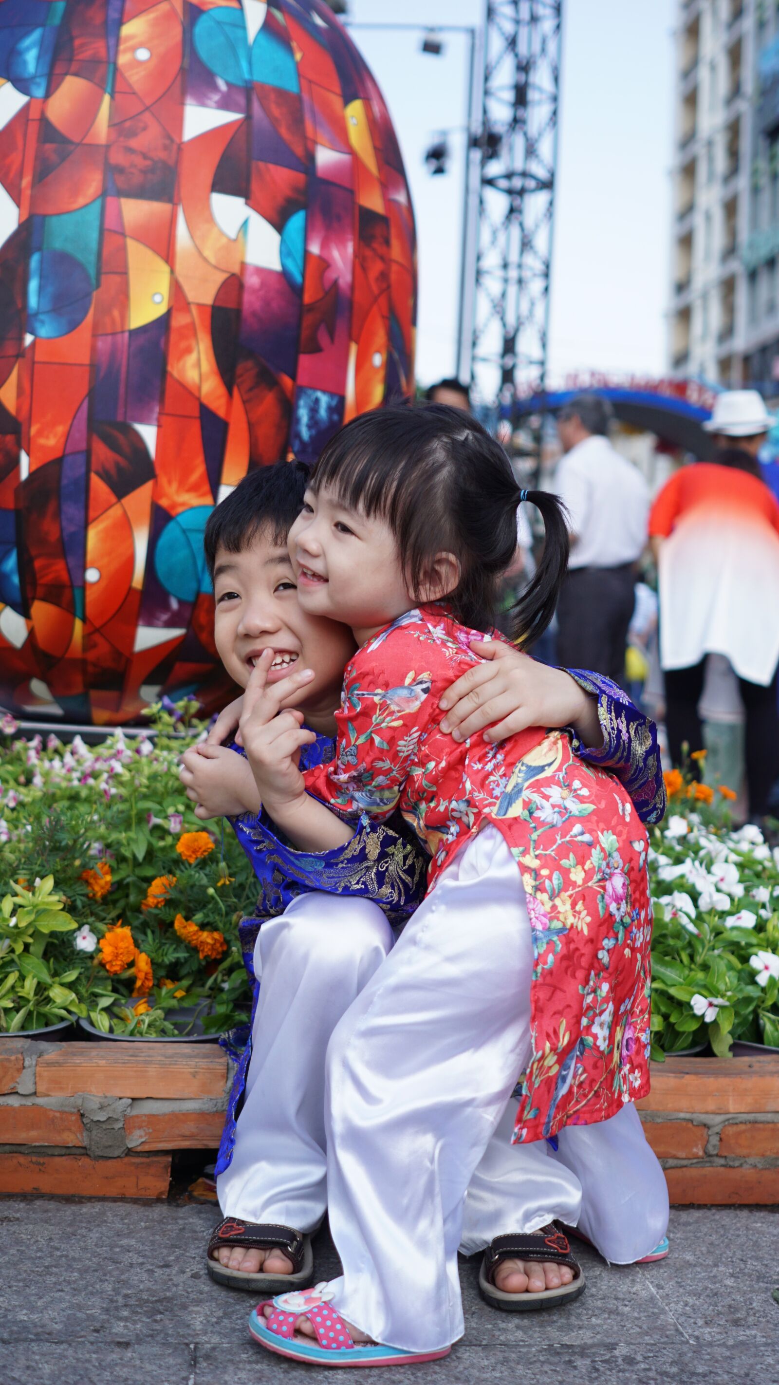 Sony a6000 + Sony FE 28mm F2 sample photo. Kids, flower, hug photography