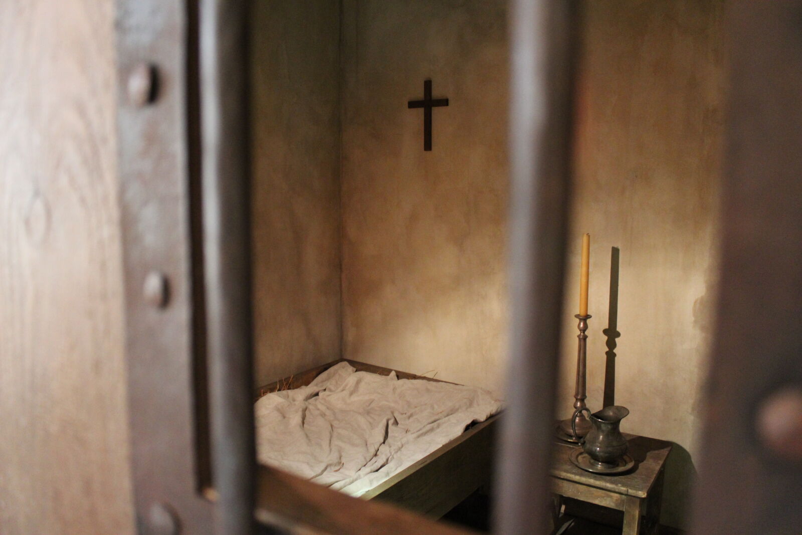 Canon EOS 1200D (EOS Rebel T5 / EOS Kiss X70 / EOS Hi) sample photo. Candles, cross, jail, window photography