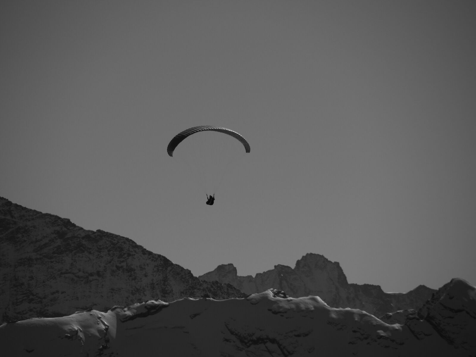 Olympus OM-D E-M5 II sample photo. Parachutist, mountains, black and photography