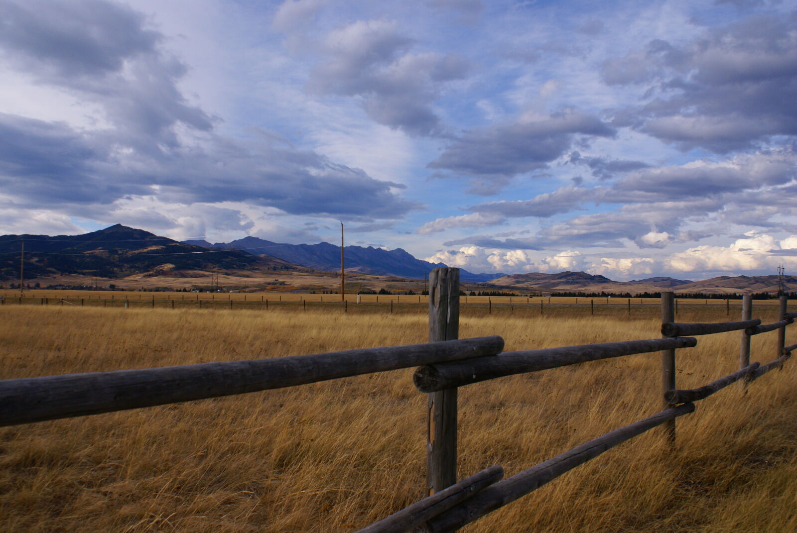 Sony DT 18-70mm F3.5-5.6 sample photo. Clouds, fence, line, grass photography