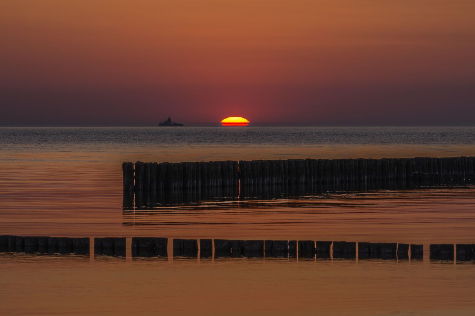 Sony E 55-210mm F4.5-6.3 OSS sample photo. Sunset, beach, groynes photography