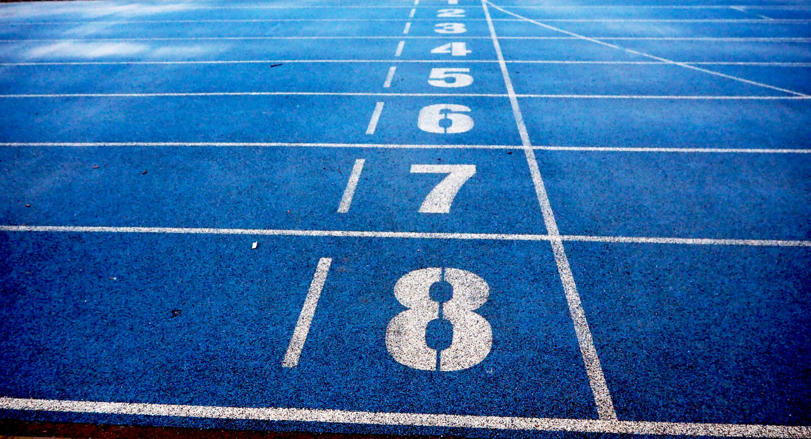 Olympus OM-D E-M10 II sample photo. Athletics, blue, ground, lanes photography