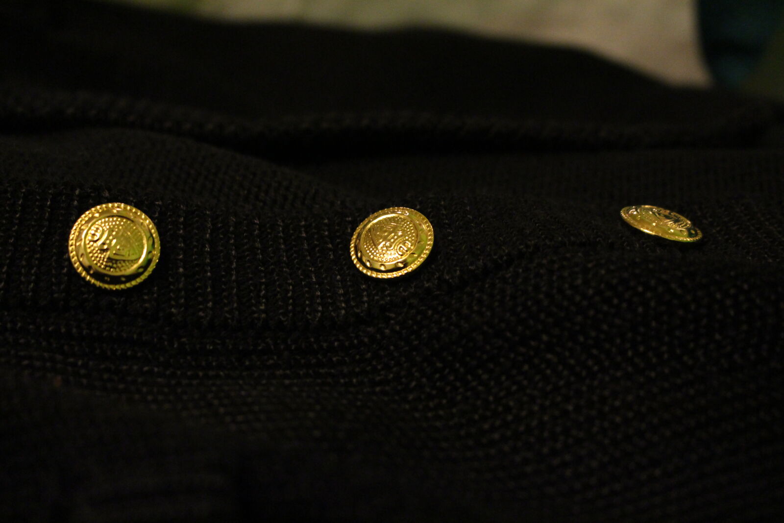 Canon EF-S 18-55mm F3.5-5.6 IS STM sample photo. Black, buttons, gold, jumper photography