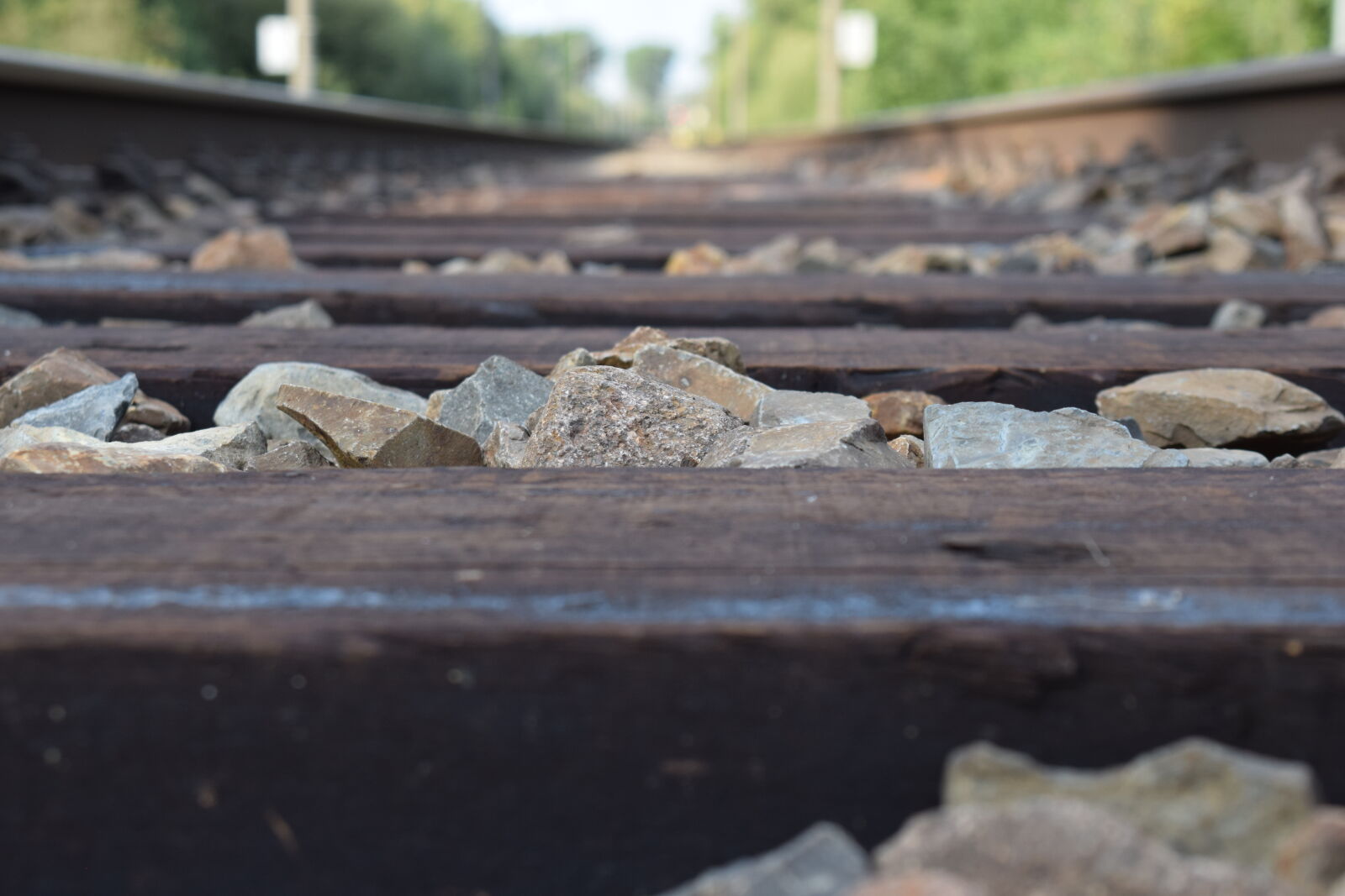 Nikon AF-P DX Nikkor 18-55mm F3.5-5.6G sample photo. Closeup, gravel, rails, stones photography