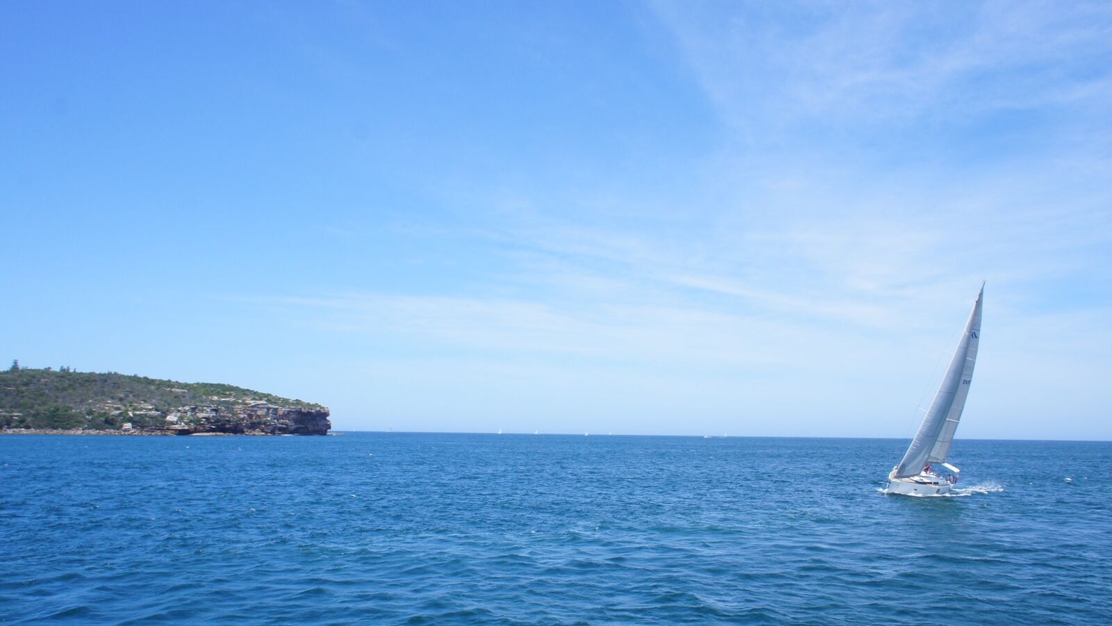 Sony Alpha NEX-C3 + Sony E 16mm F2.8 sample photo. Blue, boat, cliff, sailboat photography
