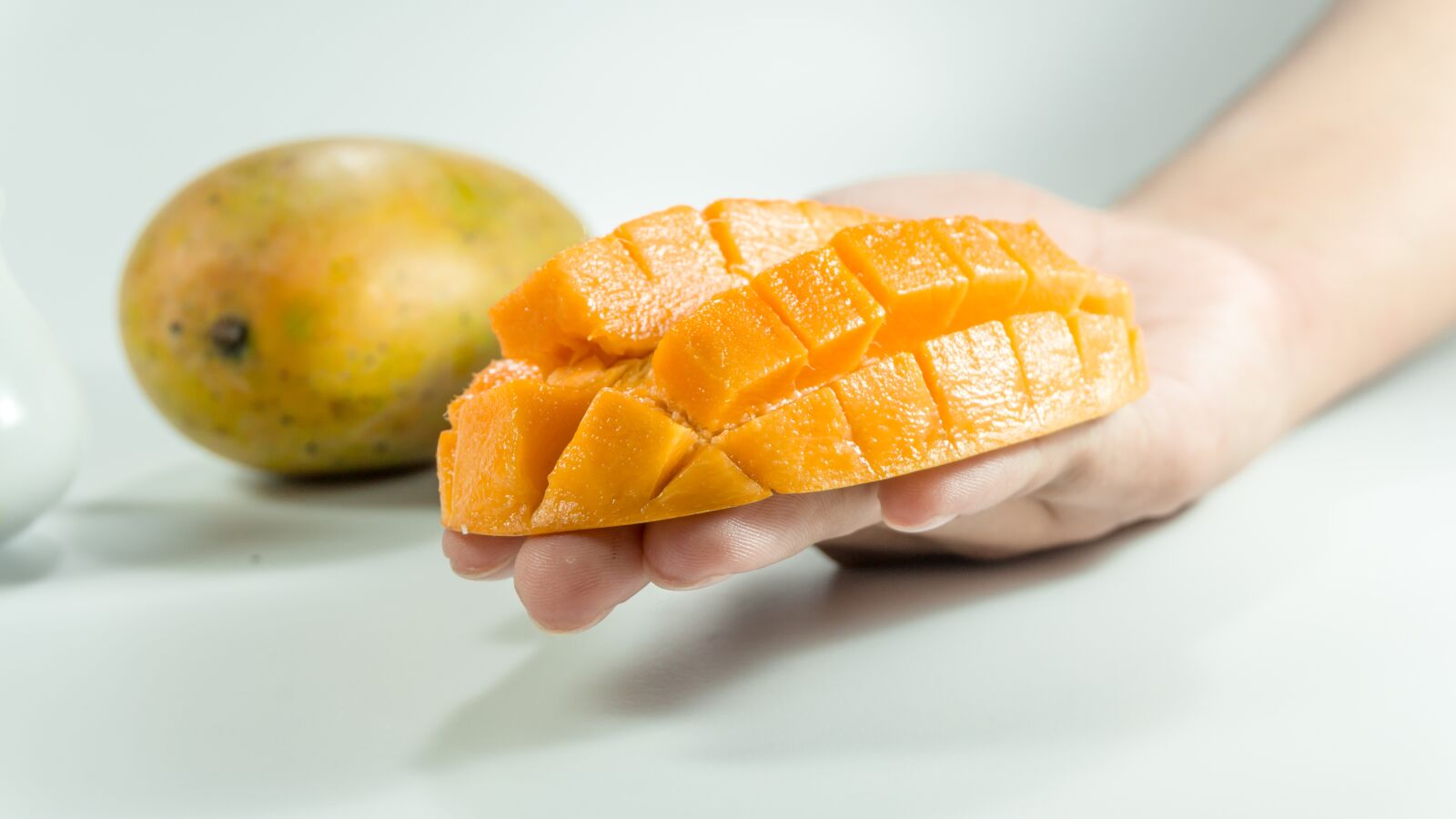 Sony a5100 sample photo. Mango, slice, on hand photography