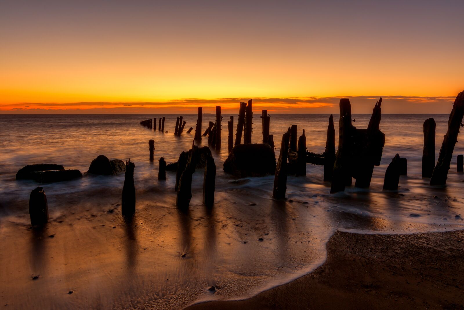 Tokina AT-X Pro 11-16mm F2.8 DX II sample photo. Waves, wooden poles, ocean photography