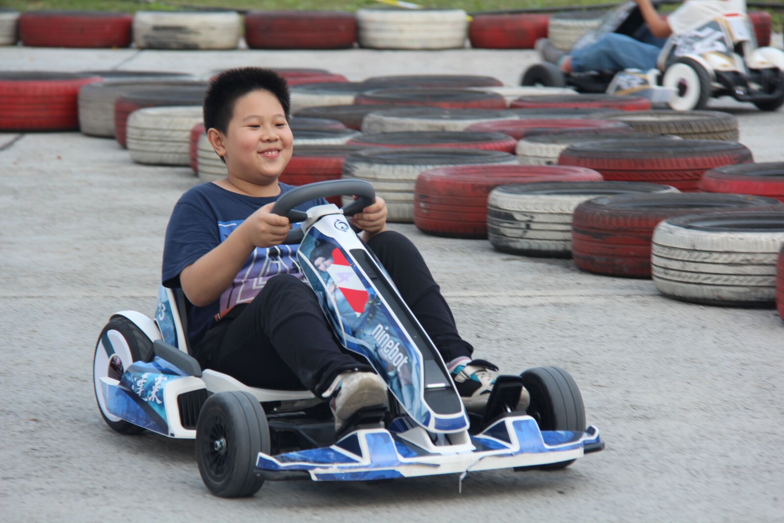 Canon EF-S 18-200mm F3.5-5.6 IS sample photo. Child, kart, happy photography