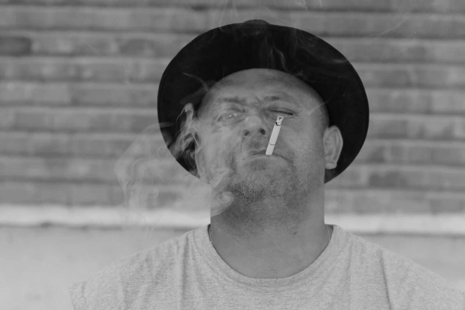 Canon EOS 700D (EOS Rebel T5i / EOS Kiss X7i) + Canon EF 85mm F1.8 USM sample photo. Man, hats, cigarette photography