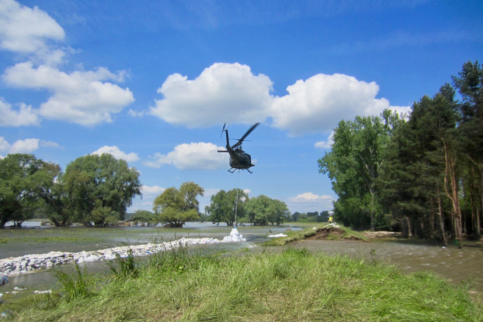 Canon PowerShot ELPH 300 HS (IXUS 220 HS / IXY 410F) sample photo. Flooded, helicopter, river, sacks photography