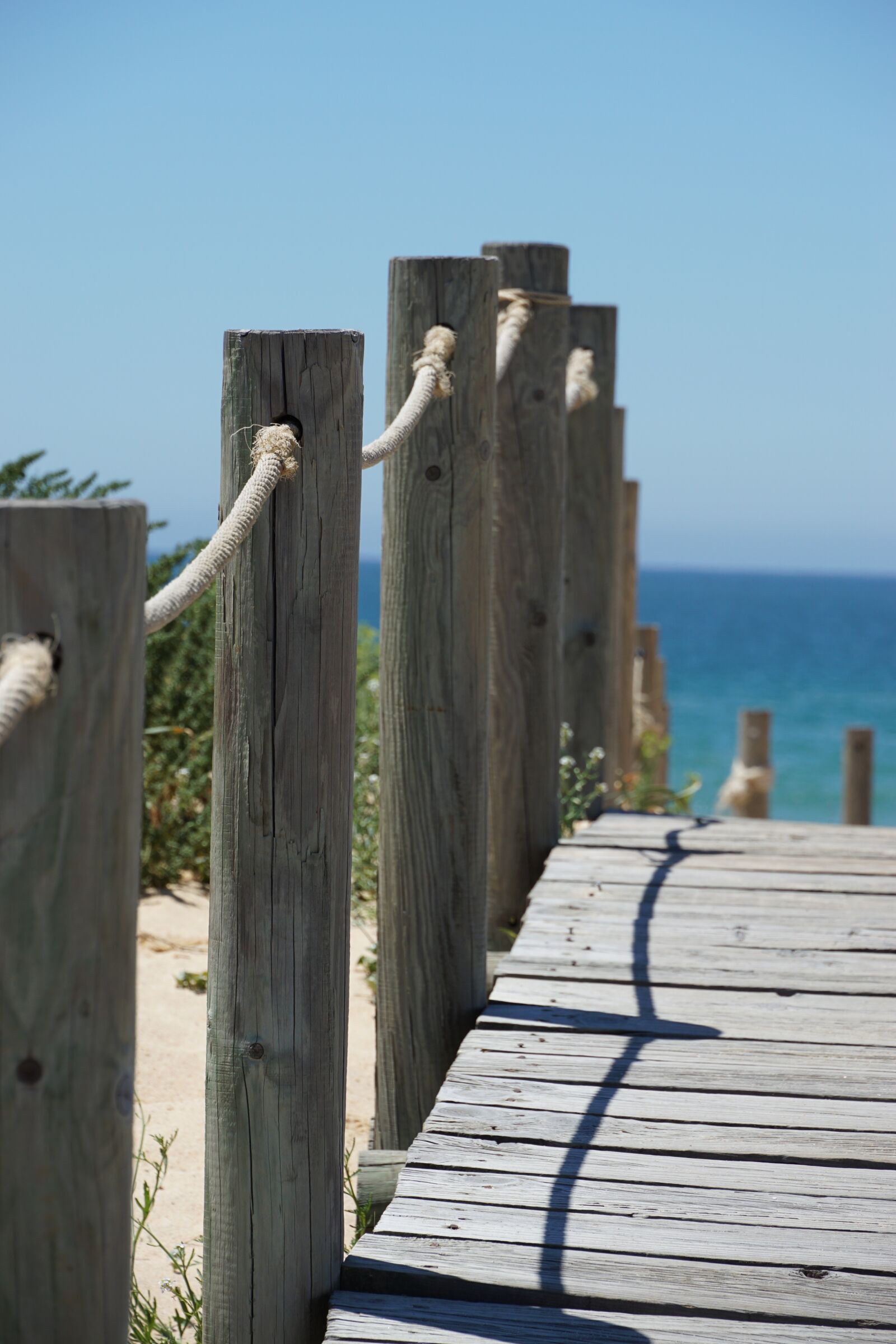 Sony E 18-135mm F3.5-5.6 OSS sample photo. Wooden track, away, sea photography