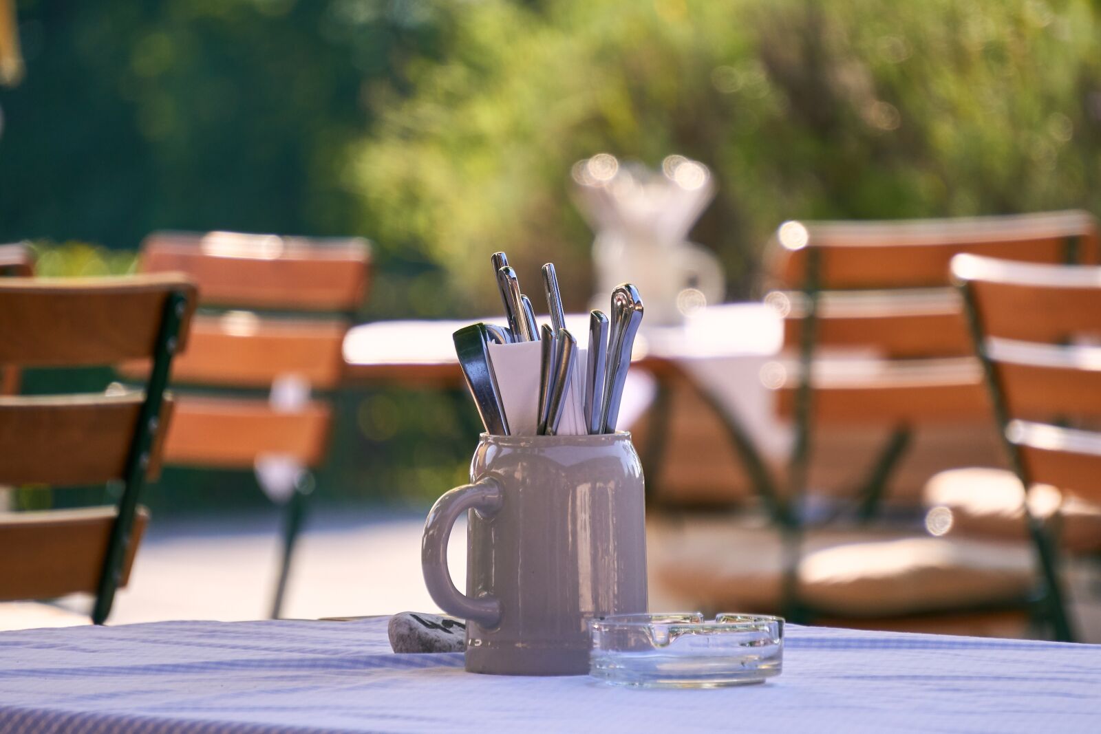 Sony E 55-210mm F4.5-6.3 OSS sample photo. Beer garden, chair, cutlery photography