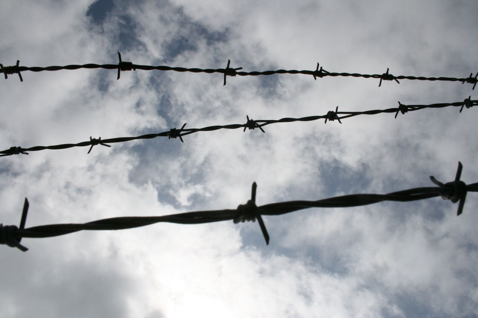 Canon EOS 400D (EOS Digital Rebel XTi / EOS Kiss Digital X) sample photo. Sky, barbed wire, clouds photography