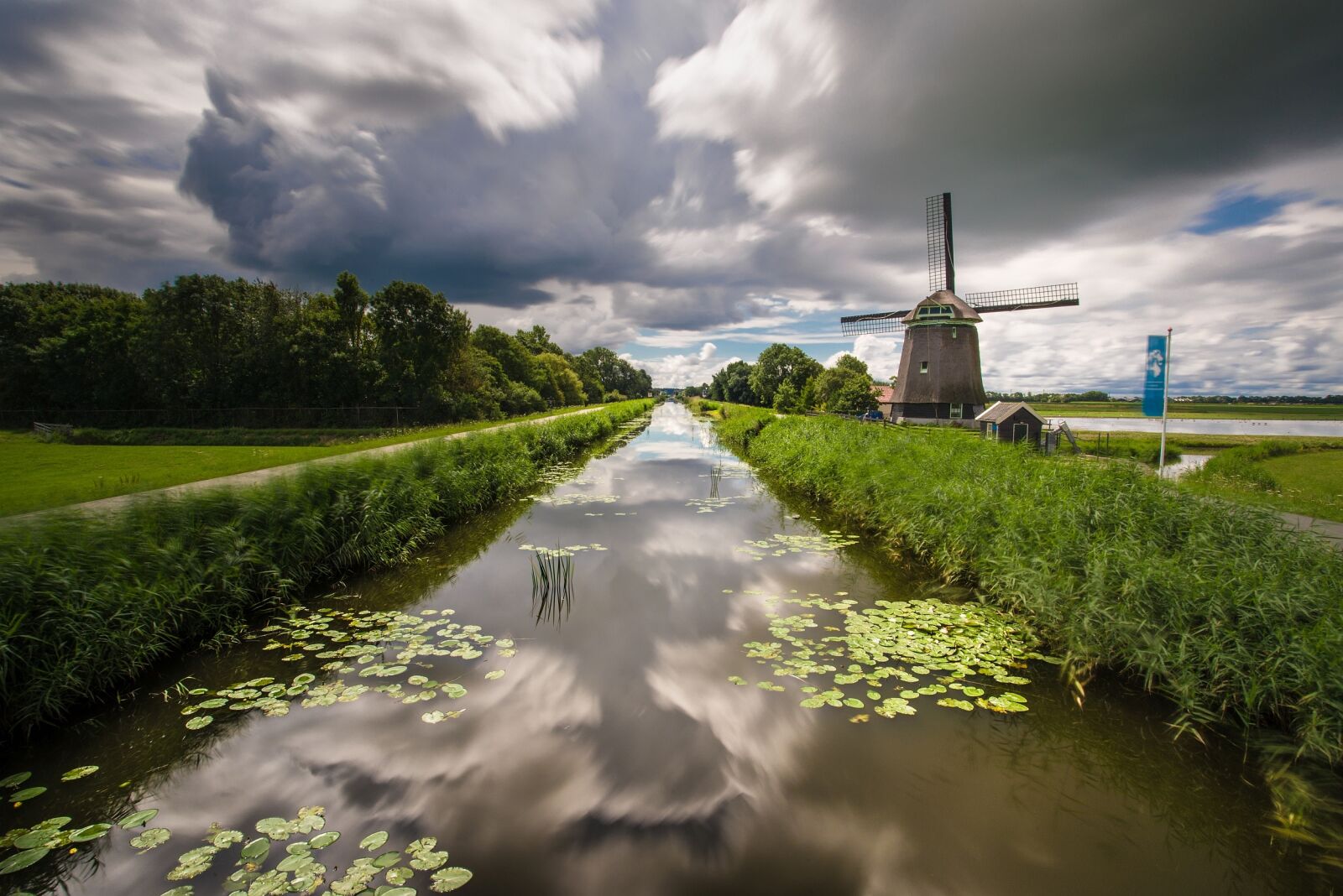 Nikon D600 sample photo. Clouds, water, windmill photography