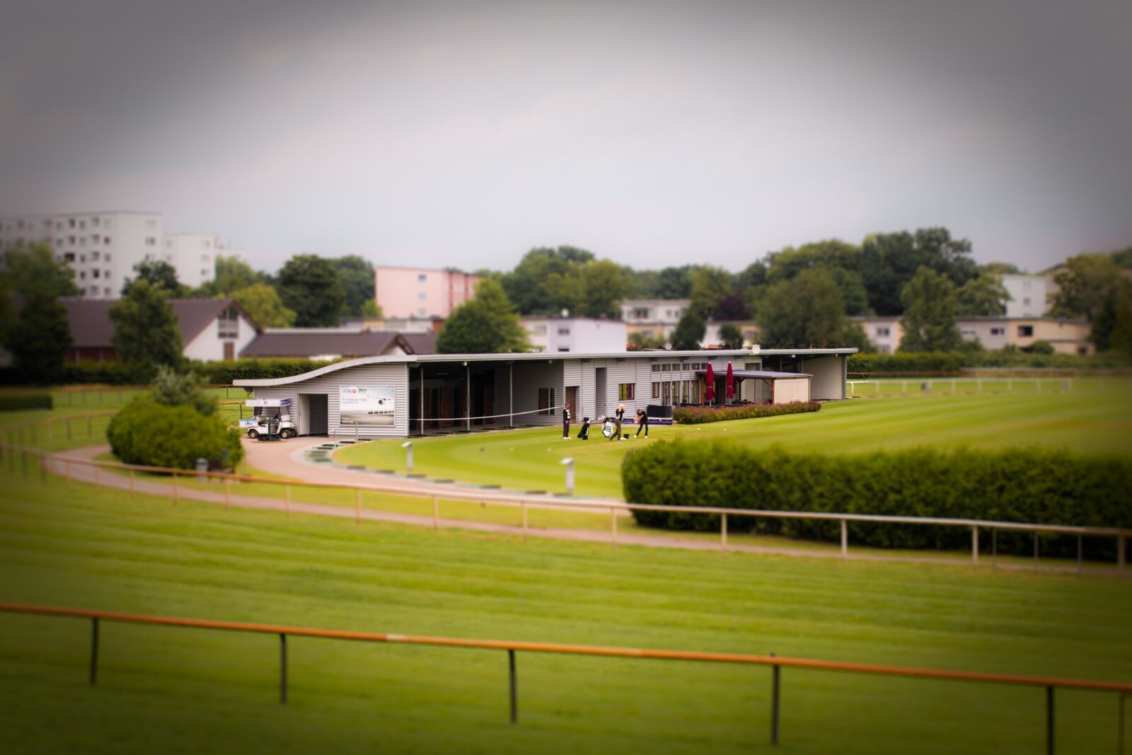 Canon EOS 70D + Canon EF 40mm F2.8 STM sample photo. Golfers, golf course, tilt photography