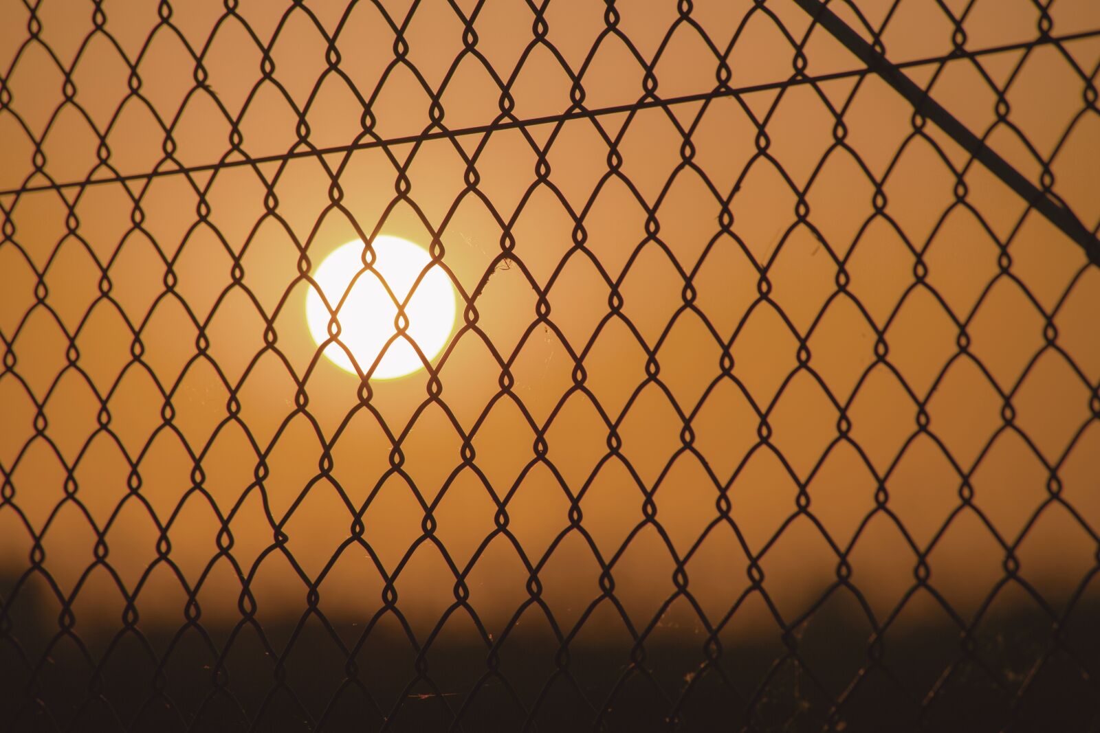 Canon EF 70-300mm F4-5.6 IS USM sample photo. Sunset, fence, grid photography