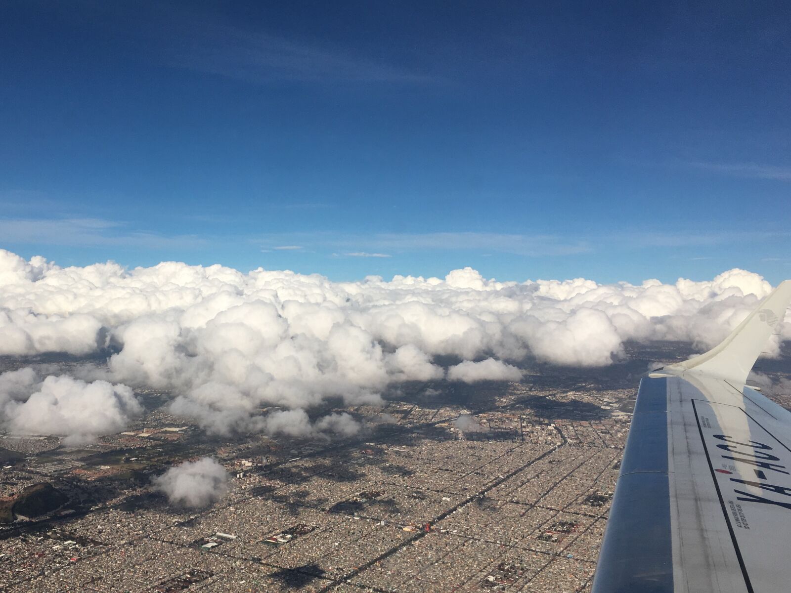 Apple iPhone 6s Plus sample photo. Cloud over city, flight photography
