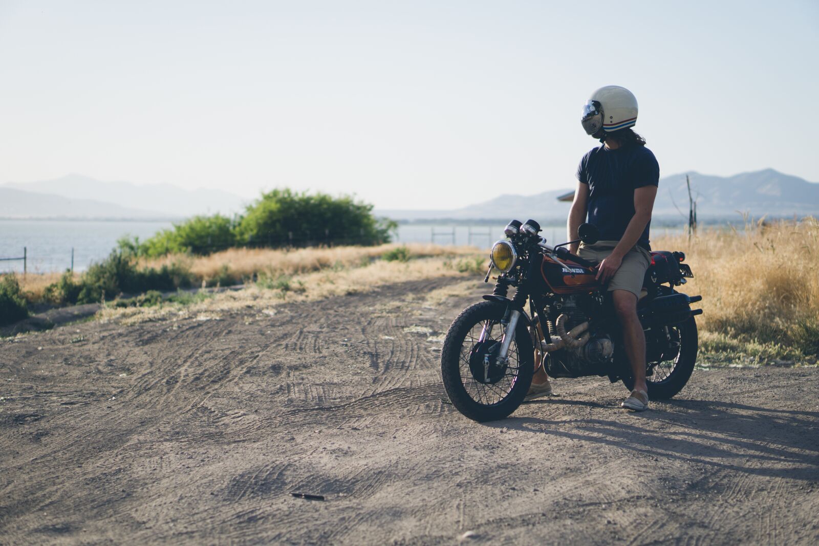 E 50mm F1.8 OSS sample photo. Dirt road, man, motorcycle photography