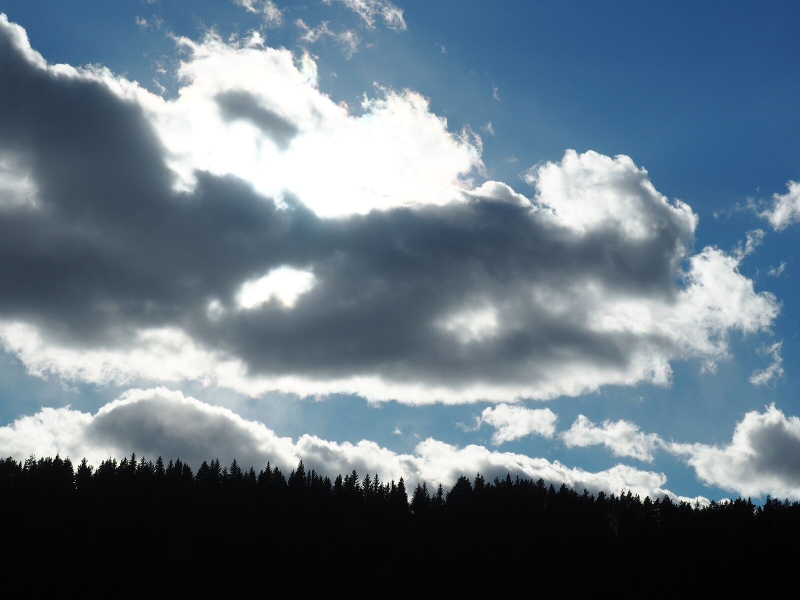 Olympus PEN E-PL7 sample photo. Clouds, sun behind the photography