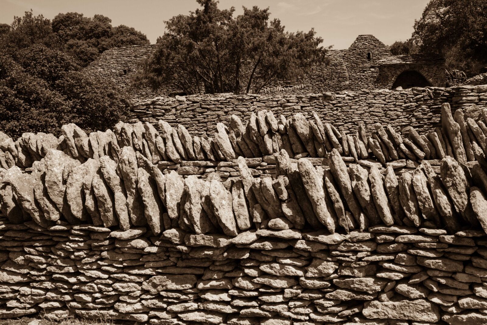Canon EF-S 18-200mm F3.5-5.6 IS sample photo. Stones, trees, wall photography