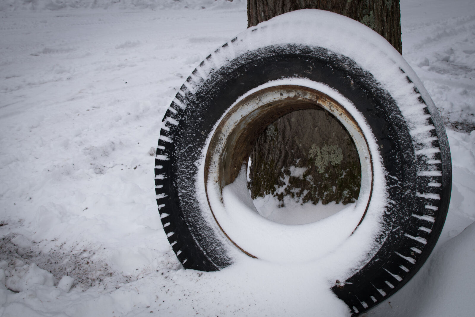 Nikon D5300 + Nikon AF-S DX Nikkor 35mm F1.8G sample photo. Abandoned, contrast, snow, tire photography