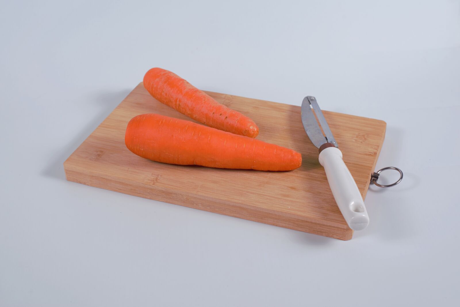 Nikon D610 sample photo. Carrots, peeler, chopping board photography