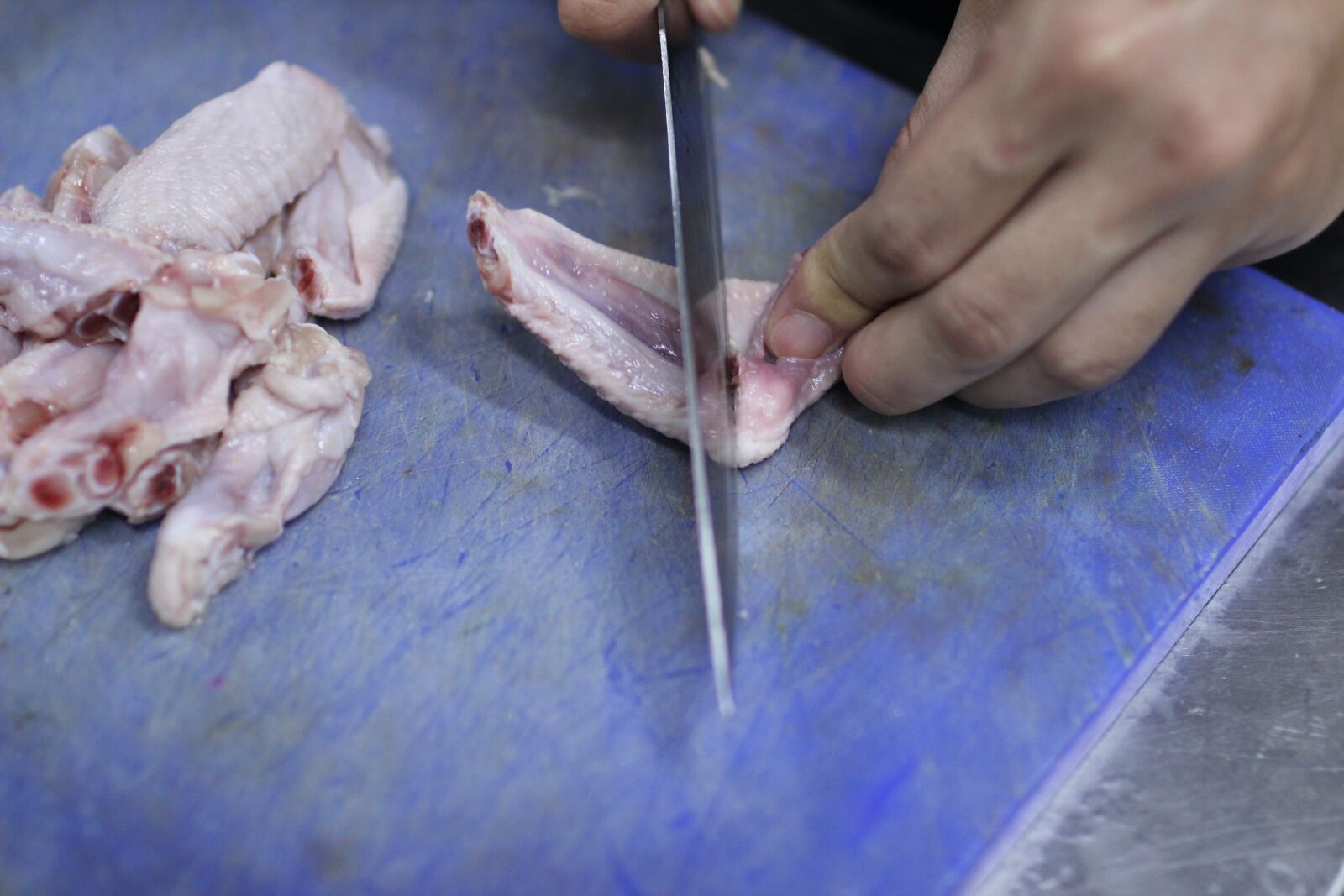Canon EOS 600D (Rebel EOS T3i / EOS Kiss X5) + Canon EF 35mm F1.4L USM sample photo. Hand cutting, knife, chicken photography