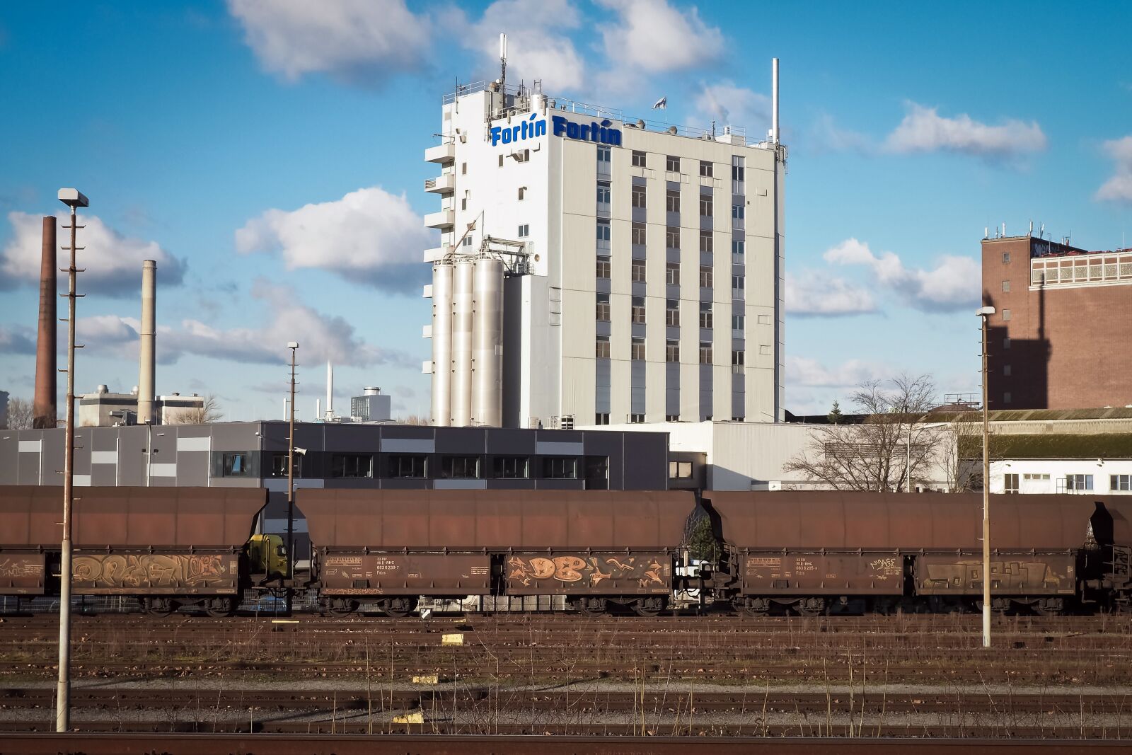 Olympus OM-D E-M10 sample photo. Freight cars, factory, chimneys photography