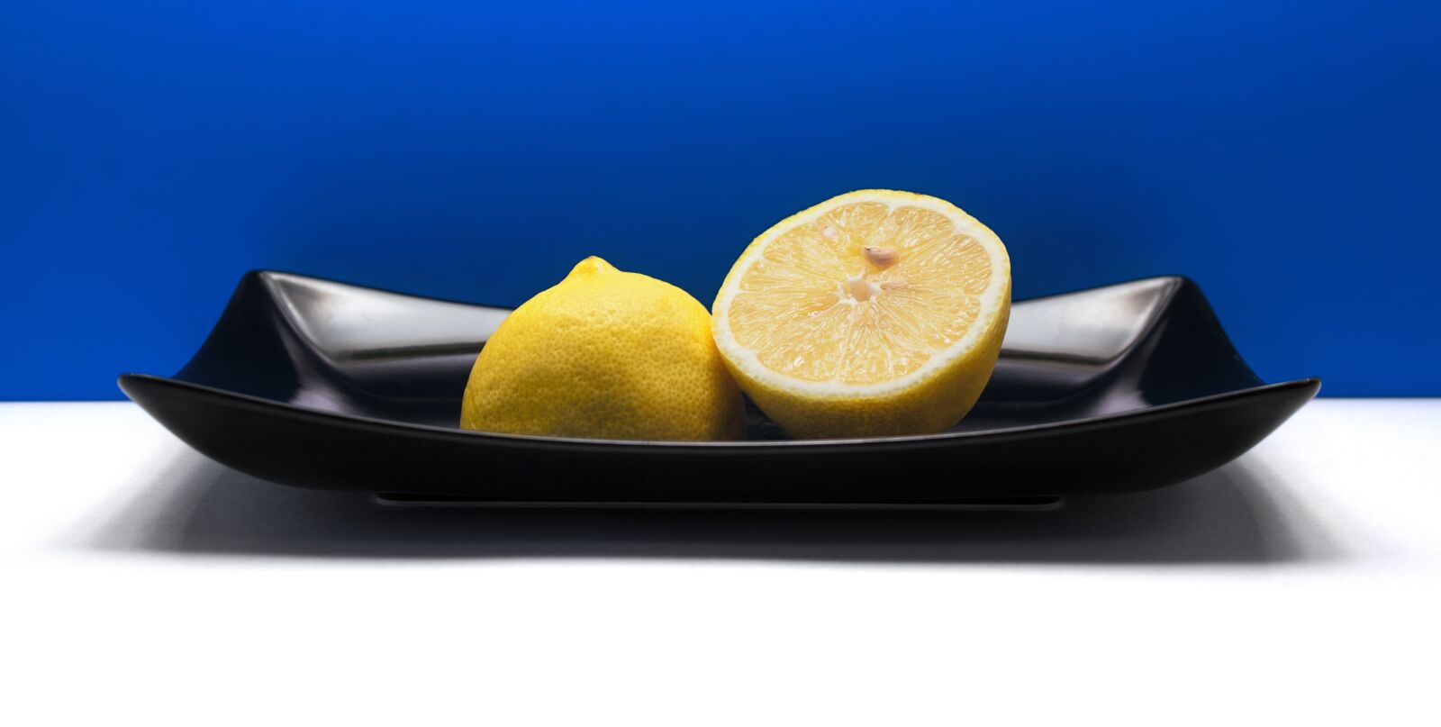 Canon EF-S 18-55mm F3.5-5.6 IS sample photo. Lemon, fruit, black plate photography